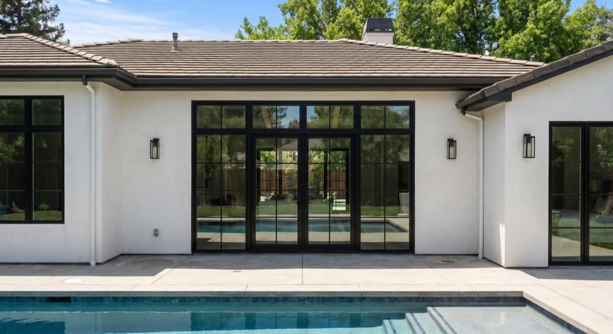 Black-grid glass patio doors opening to a pool by Mad Touch Glass